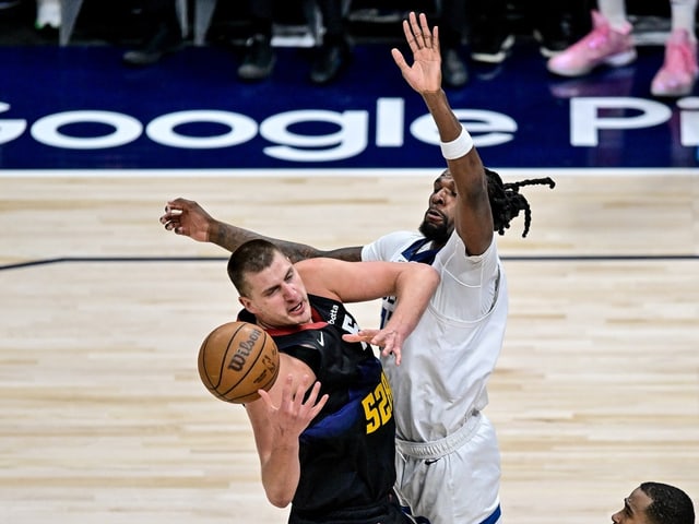 Zwei Basketballspieler im Wettkampf um den Ball während eines Spiels.