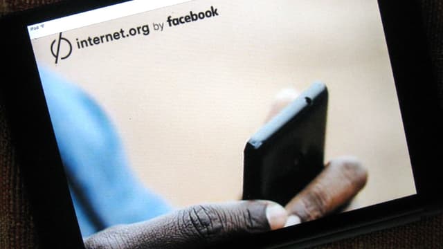 Eine Bildschirmaufnahme von «Free Basics». Man sieht eine Hand mit einem Smartphone.