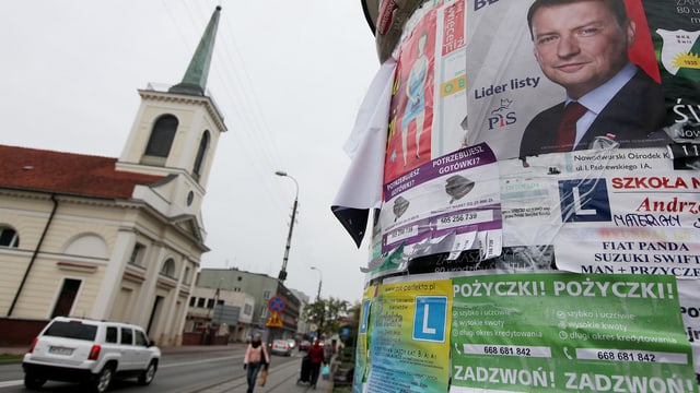 Polnische Wahlplakate im Vordergrund, im Hintergrund eine Kirche.