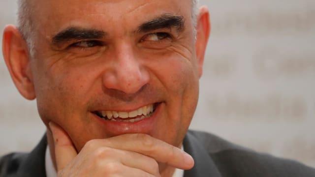 Nahaufnahme von Alain Berset, Mann mit grauen Haaren und buschigen Augenbrauen lächelt, stützt Gesicht auf Händen ab