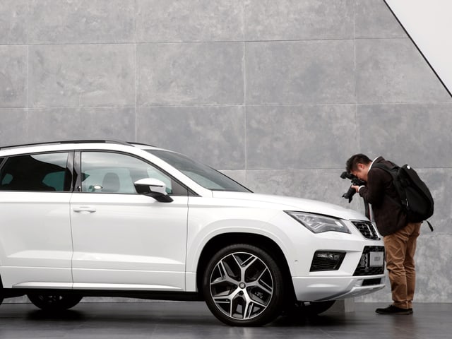 Ein Fotograf fotografiert die Motorhaube eines Seat Ateca von ganz nahe.