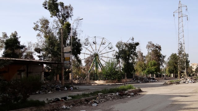 Zerstörte Strasse mit stillstehendem Riesenrad