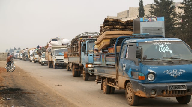 Lastwagen transportieren die Habseligkeiten von Menschen.