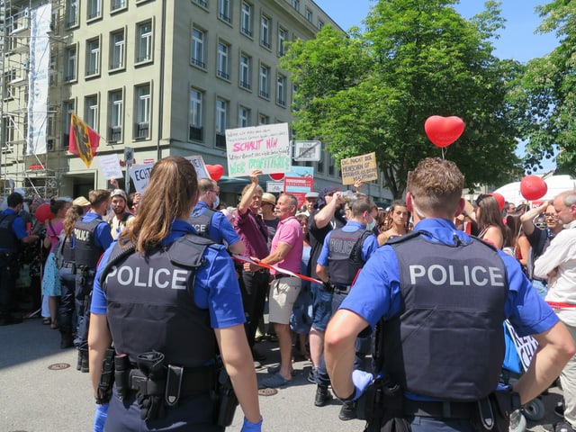 Two police officers in front of the protester.