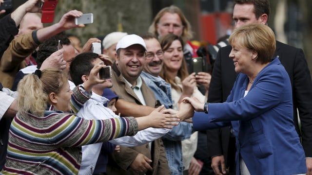 Angela Merkel schüttelt hände vor einer Konferenz über die Flüchtlingskrise in Duisburg.