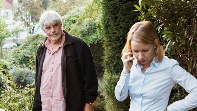 Ein Mann (links) und eine Frau (rechts), die Frau ist am Telefon.