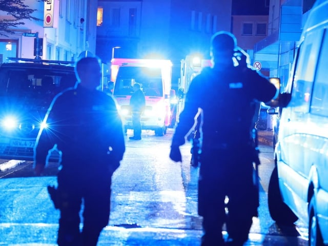 Polizeieinsatz bei Nacht mit blauem Licht auf der Strasse.