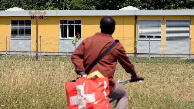 Asylbewerber vor Unterkunft.