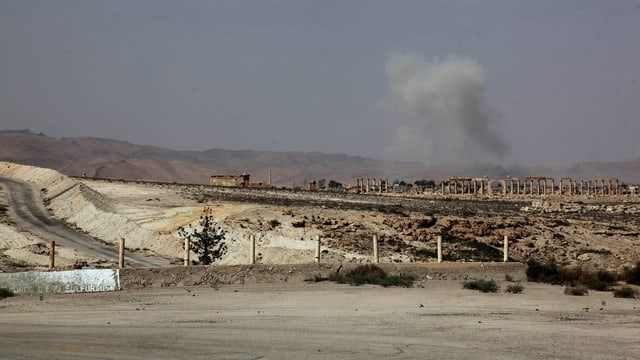 Nach einem Angriff mit Raketenwerfern steigt Rauch über der syrischen Stadt Palmyra auf