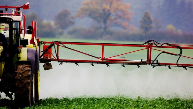 A tractor is spraying pesticides.