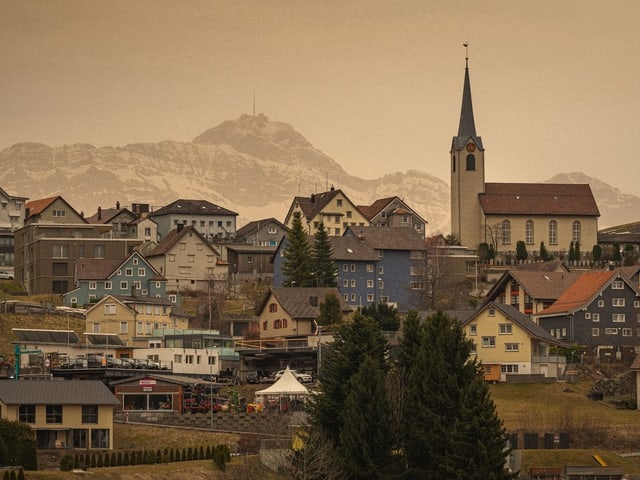 Trüber Himmel über eine Stadt mit dem Säntis im Hintergrund