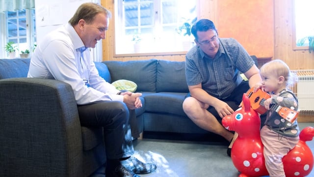 Der Schwedische Premier Stefan Löfven begrüsst bei einem Kindergartenbesuch einem kleines Mädchen und ihren Vater.