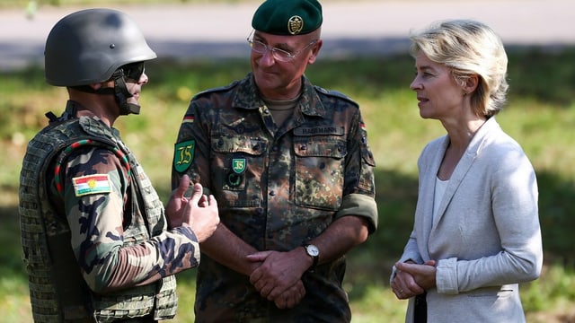 Ein Peschmerga-Kämpfer, ein deutscher Offizier und von der Leyen in einem Gespräch