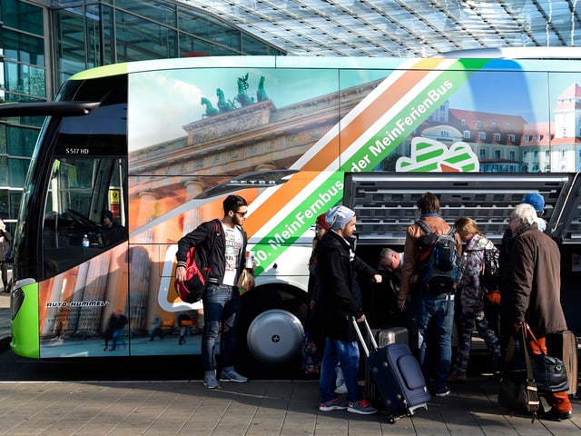 Leute steigen in einen Fernbus ein.