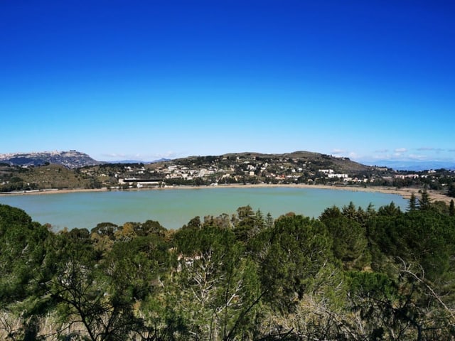 Ein Bergsee mit Wald und einem Dorf 