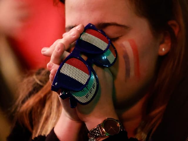 Eine Frau mit Frankreich-Brillen mit geschlossenen Augen und gefalteten Händen vor dem Gesicht.