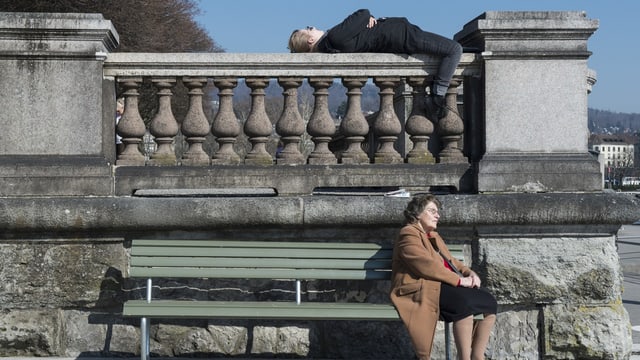 Alte und junge Frau sonnen sich auf einer Bank