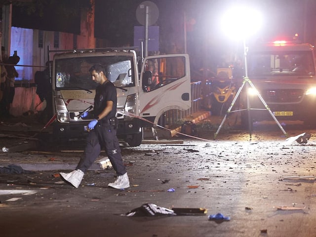 Polizist untersucht Tatort nach Explosion bei Nacht.