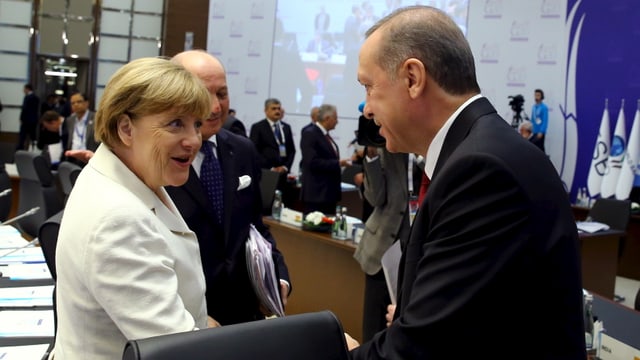 Angla Merkel (links) schüttelt Recep Tayyip Erdogan (rechts) lachend die Hand.