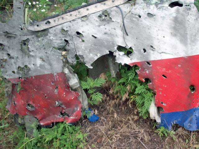 Ein Teil des Flugzeug-Wracks. Es ist von Löchern durchzogen.