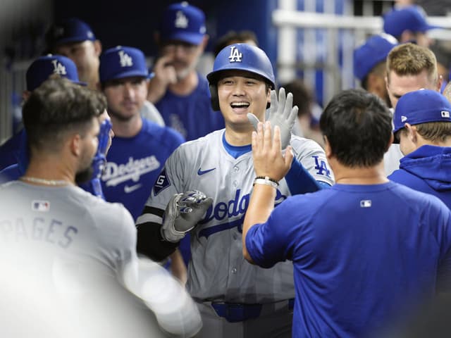 Baseballspieler der Dodgers erhält High-Fives von Teamkollegen in der Umkleide.