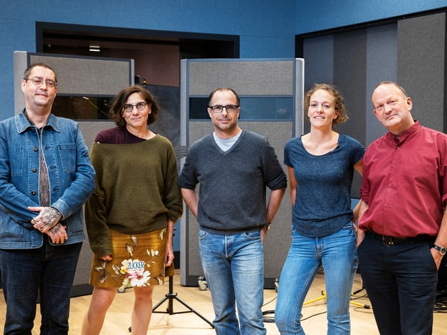 Fünf Personen stehen nebeneinander in einem Radiostudio