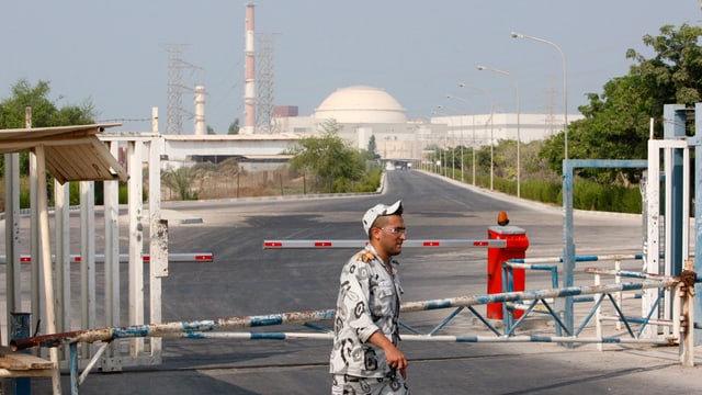 Ein Mann läuft vor einem Atomkraftwerk vorbei. 