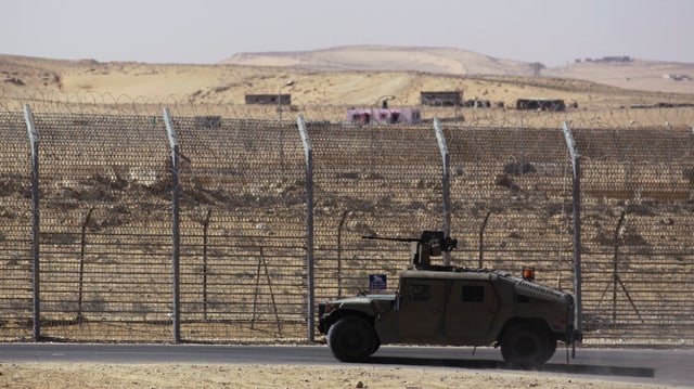 Ein Militärfahrzeug fährt der israelisch-ägyptischen Grenze entlang, im Hintergrund ein Zaun