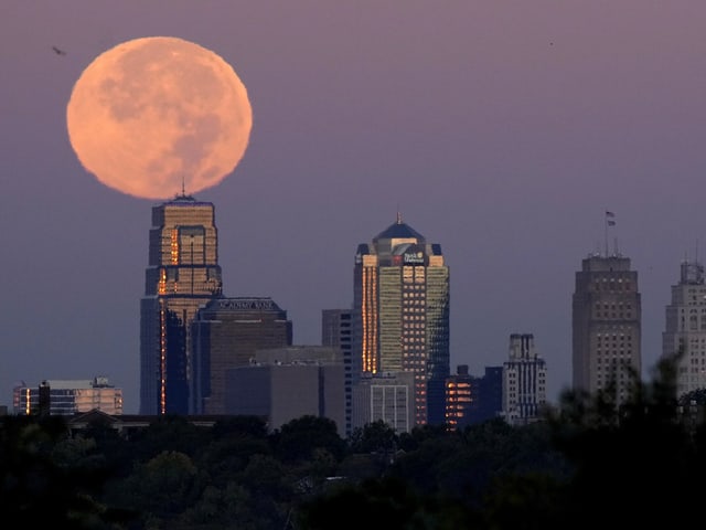 Vollmond über Stadtzentrum mit Wolkenkratzern.