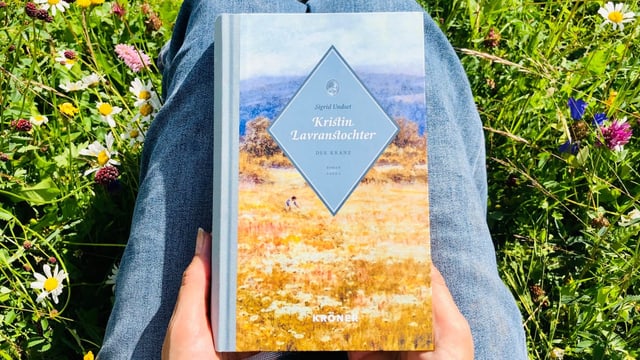 Das Buch «Kristin Lavranstochter» von Sigrid Undset liegt auf Annette Königs Knien