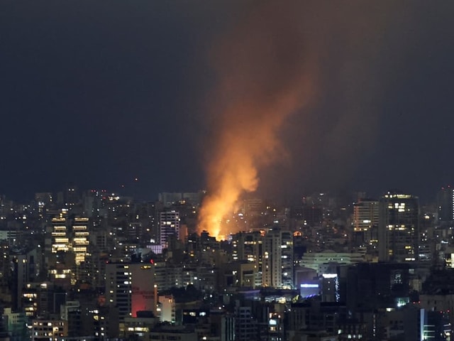 Nachtaufnahme einer Stadt mit grossem Feuer.