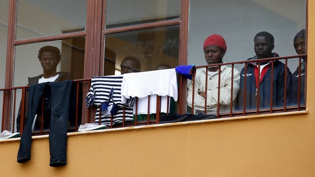 Dunkelhäutige Menschen auf einem Balkon mit Wäsche