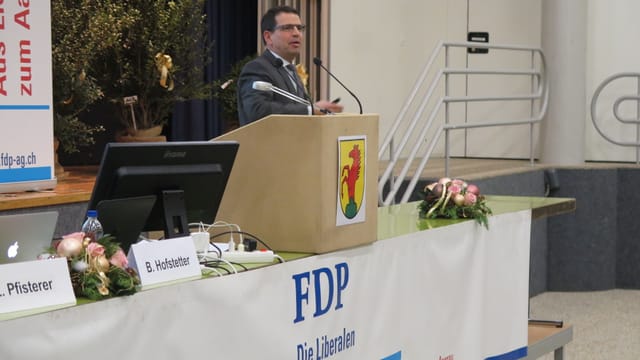 Mann an Rednerpult, Logo der FDP daran.