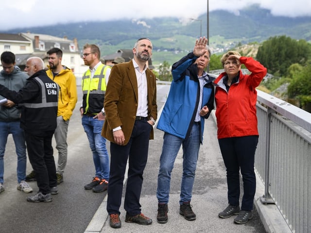 Viola Amherd lässt sich auf einer Brücke das Ausmass der Zerstörung zeigen.