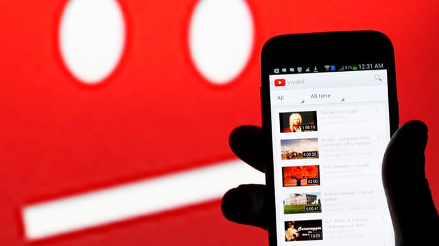 Jemand hält ein Smartphone mit Youtube-App in der Hand.