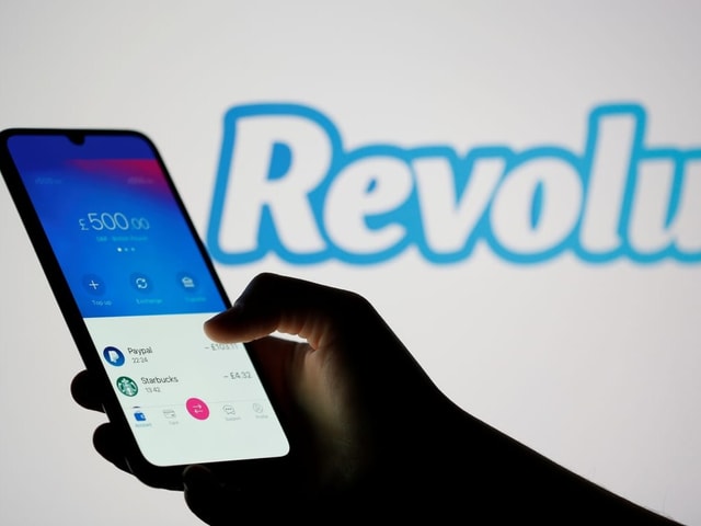 Eine Hand hält ein Handy in der Hand, worauf die Revolut-App geöffnet ist.