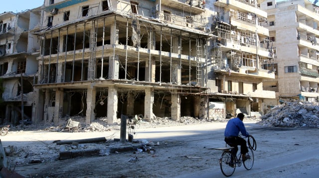 Zerstörter Strassenzug in Aleppo, Velofahrer auf Strasse