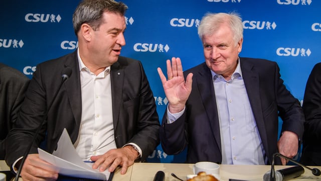 Zwei Männer, der ältere (Seehofer) winkt.