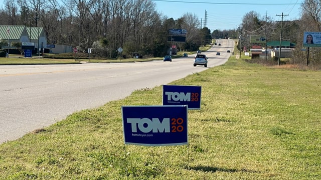 Kleine Plakate mit TOM2020 stehen am Strassenrand