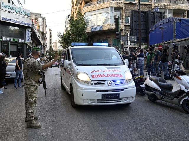 Soldat stoppt Krankenwagen in Stadtstrasse.