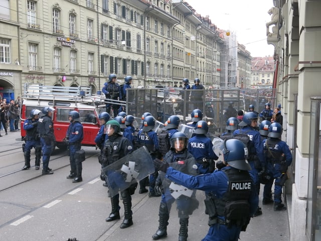 Polizisten mit Absperrgittern.