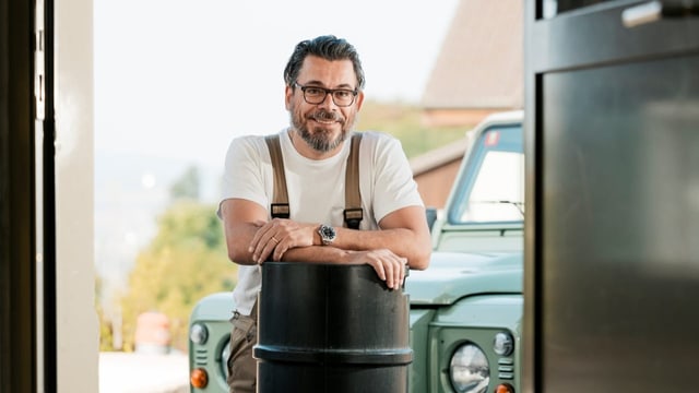 In der Brauerei: Urs Meier stützt seine Arme auf ein Fass und lächelt.