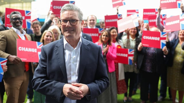 Starmer vor einer Gruppe von Menschen mit 'Change'-Schildern.