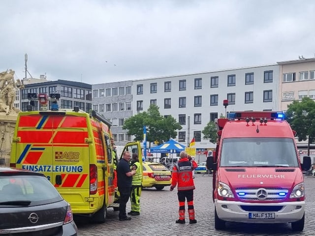 Einsatzfahrzeuge und Einsatzkräfte der Feuerwehr auf einem Stadtplatz.