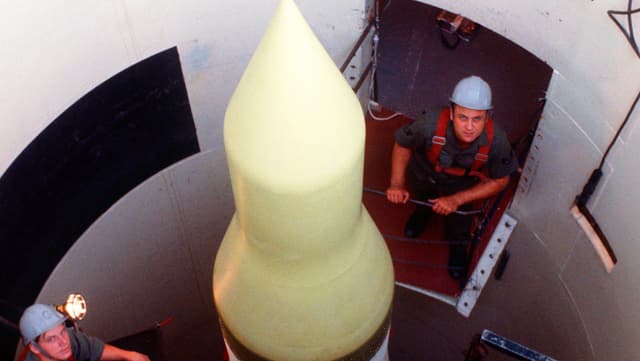 Arbeiter mit Helm in einem Raketensilo.