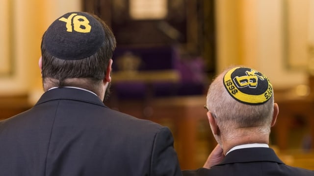 Zwei Kippatragendes Männer von hinten. Die Kippas zeigen Symbole der Young Boys Bern