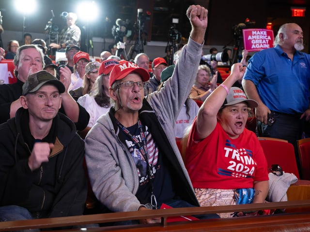 Menschen in Trump-Mützen bei einer Veranstaltung.