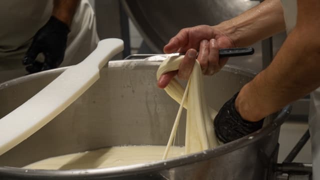 Roberto De Matteis hält einen Mozzarellastrang in der Hand.