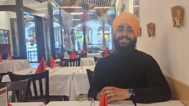 Portraitbild von Biramandeeps Sigh mit gelbem Turban in einem Restaurant. 