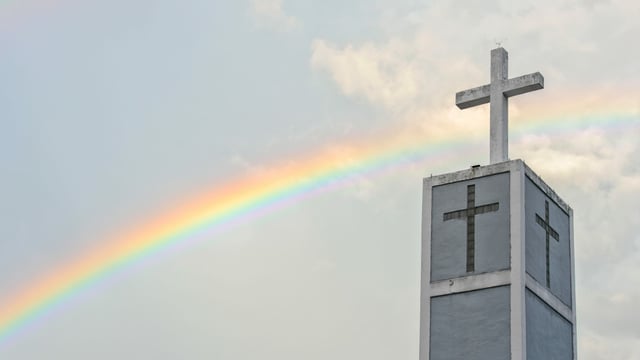 Regenbogen über einem Kirchturm.